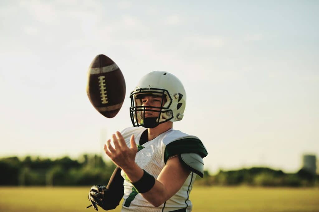 American football quarterback tossing a ball in the air