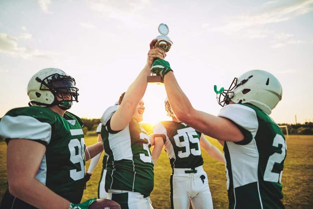 Football players raising a trophy together after winning the championship